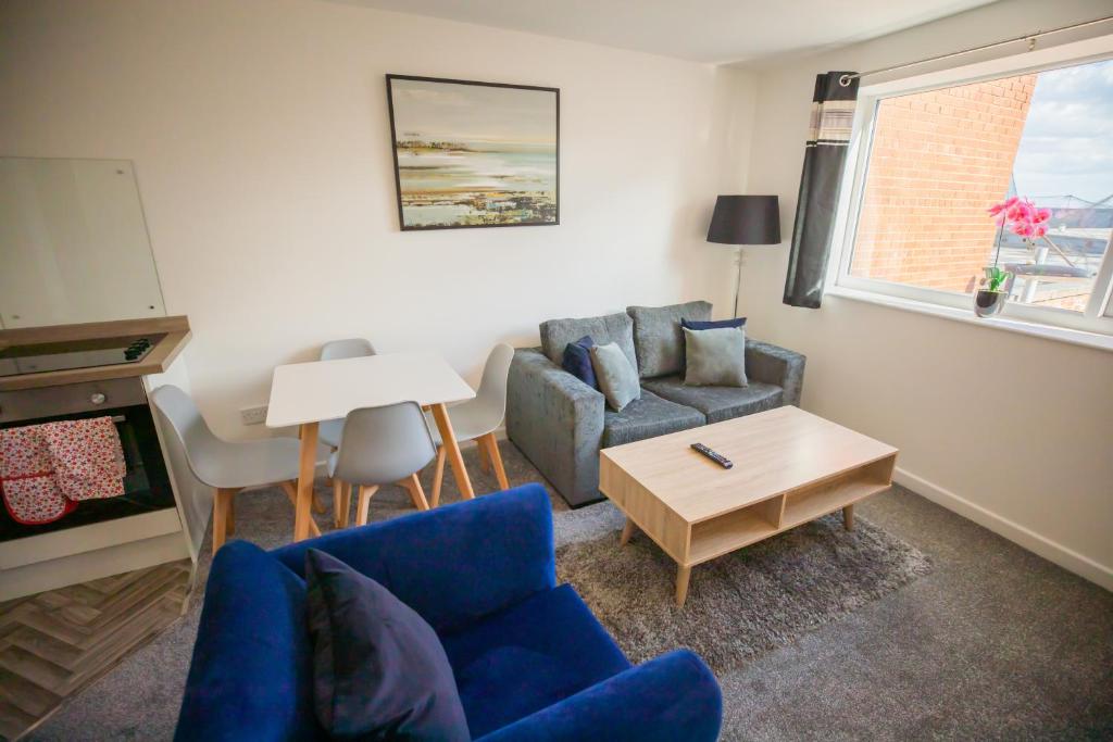 a living room with a blue couch and a table at Sigma Executive Apartment 6 in North Shields