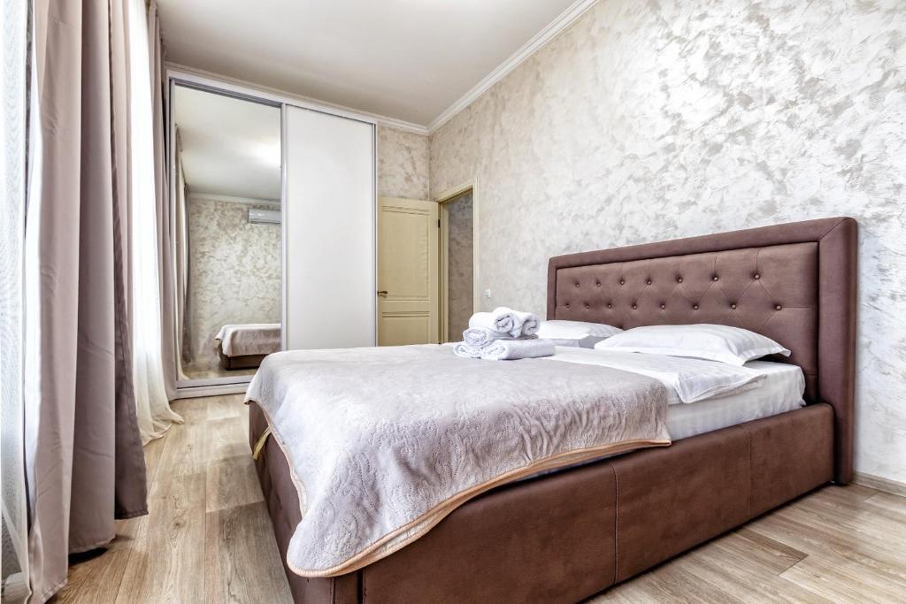 a bedroom with a large bed and a mirror at Апартаменты Променад экспо 269 in Astana