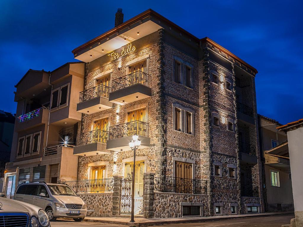 a tall brick building with balconies and a street light at Très Belle in Korçë