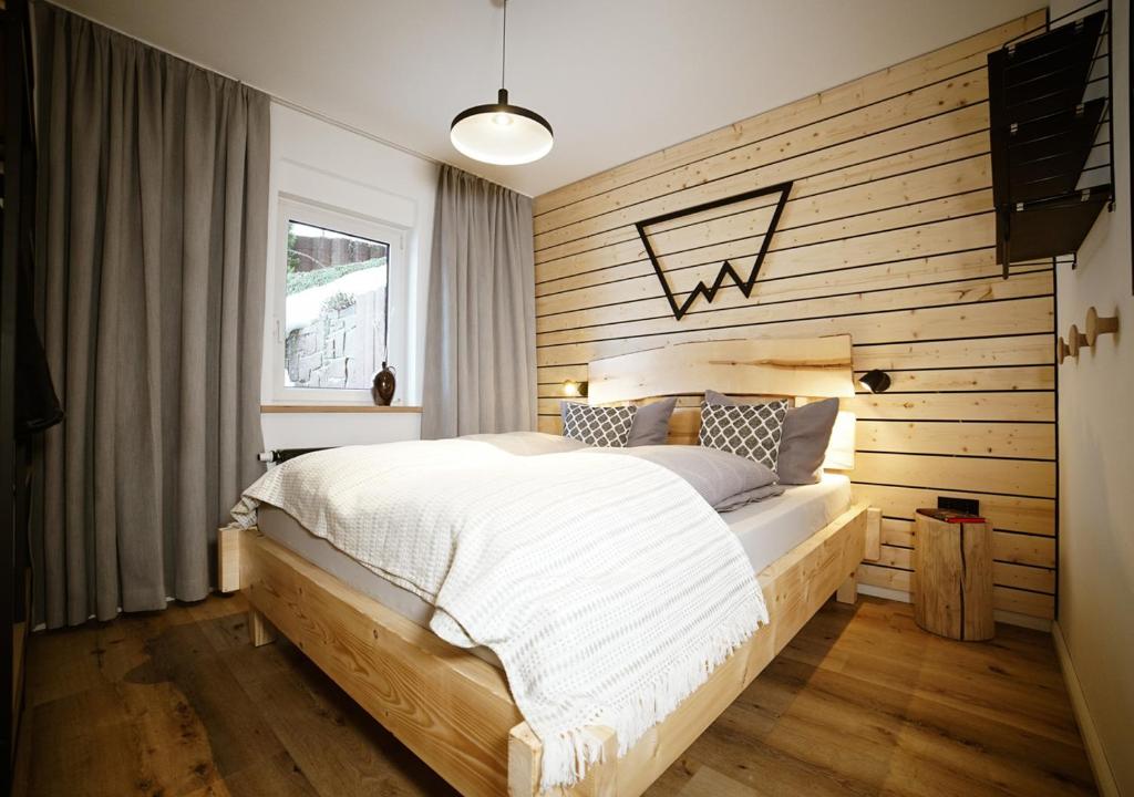 a bedroom with a bed with a wooden wall at Chalet Hans in Kurort Oberwiesenthal