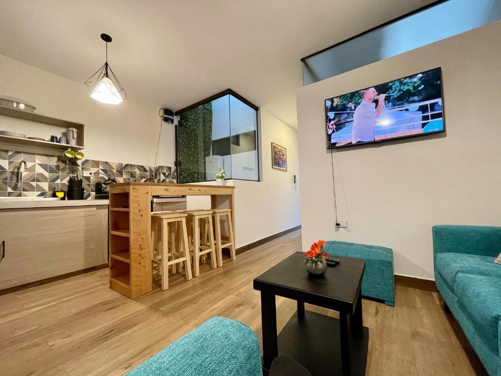 a living room with a couch and a tv on a wall at City Center 3-rooms apartment Downtown Sucre in Sucre