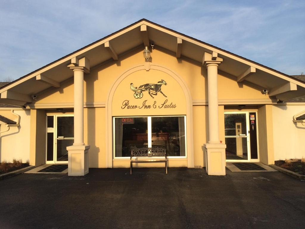 un front de magasin avec un panneau indiquant l'auberge de chevaux et le village dans l'établissement Pacer Inn & Suites Motel, à Delaware