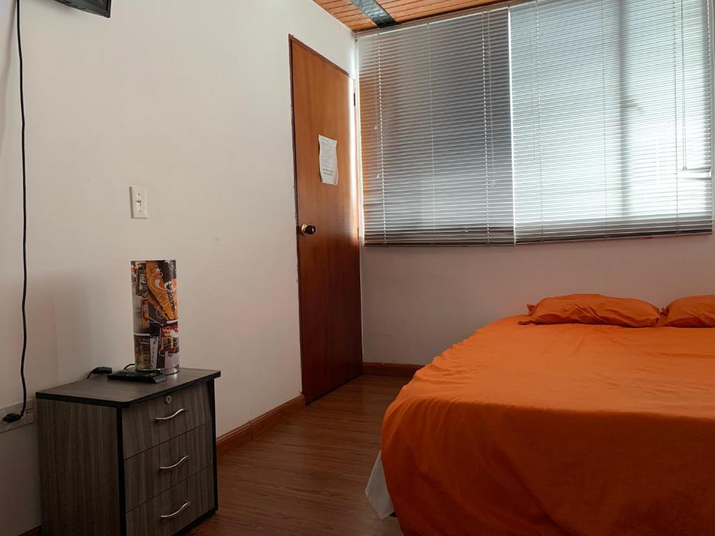 1 dormitorio con 1 cama, vestidor y ventana en Casa hotel Sports and Family, en Bogotá