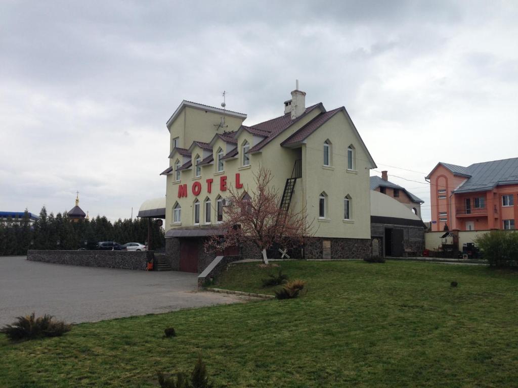 a hotel with a sign on the side of it at Formula Plus Motel in Lutsk