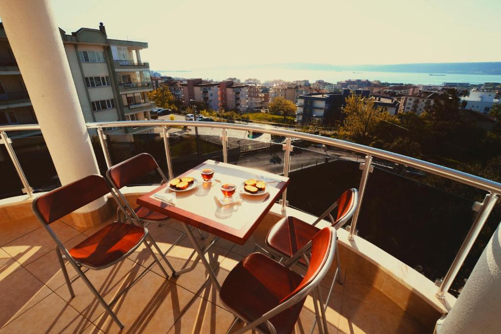 un balcón con mesa y sillas con comida. en Dort Mevsim Suit Hotel, en Canakkale