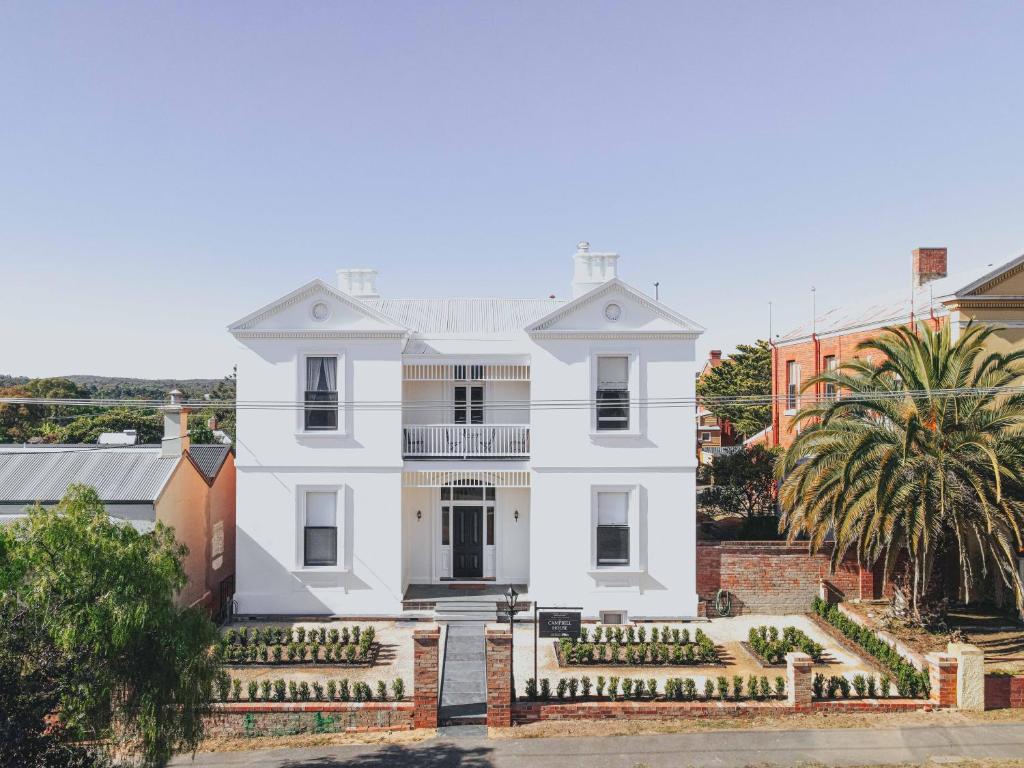 a white house with palm trees in front of it at Campbell House in Castlemaine