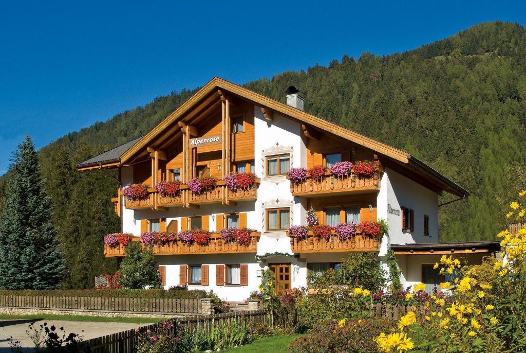 ein Gebäude mit Blumenkästen auf den Balkonen in der Unterkunft Residence Alpenrose in Rasùn di Sotto
