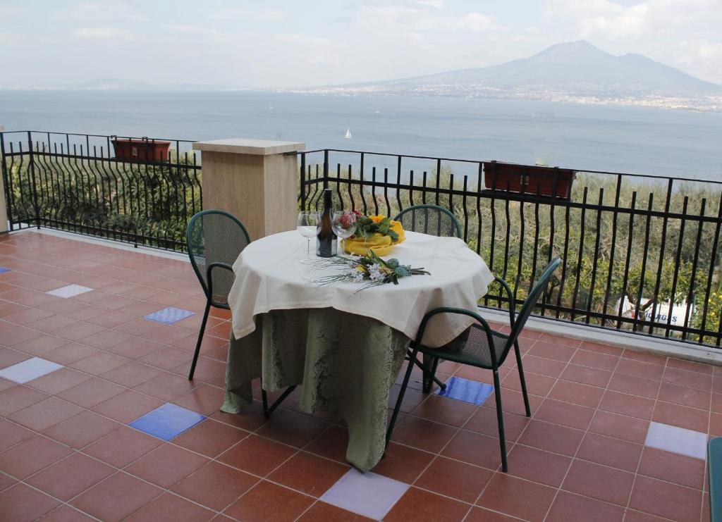 a table on a balcony with a view of the ocean at Ancelle Sorrento - Casa d'Accoglienza in Castellammare di Stabia