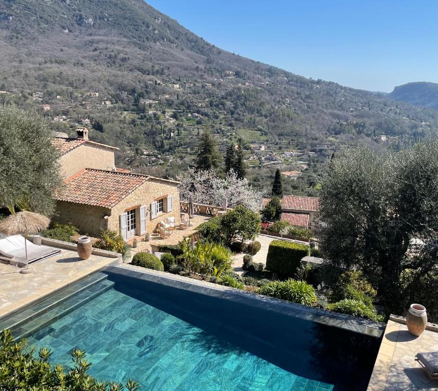 a swimming pool in front of a house with a mountain at L´Escale du Ciel in Le Bar-sur-Loup
