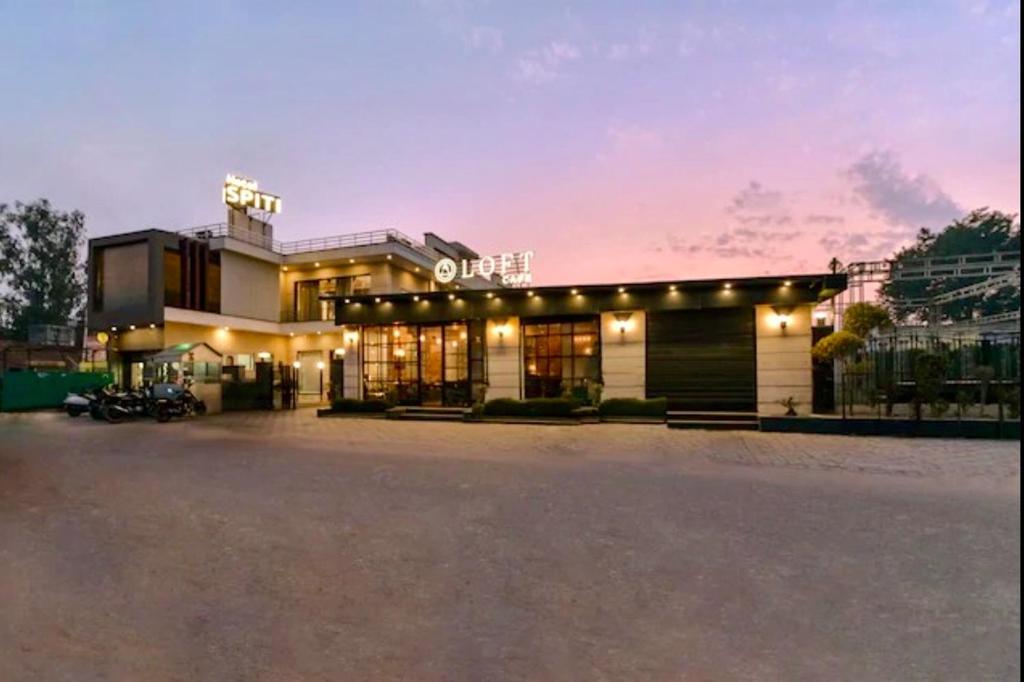 a building with a parking lot in front of it at Hotel Spiti in Mathura
