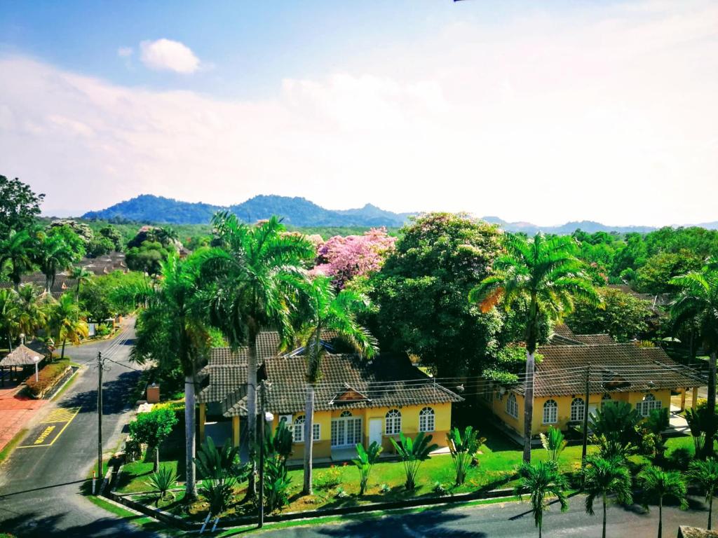 an aerial view of a yellow house with palm trees at Rumbia Resort Villa Paka in Paka