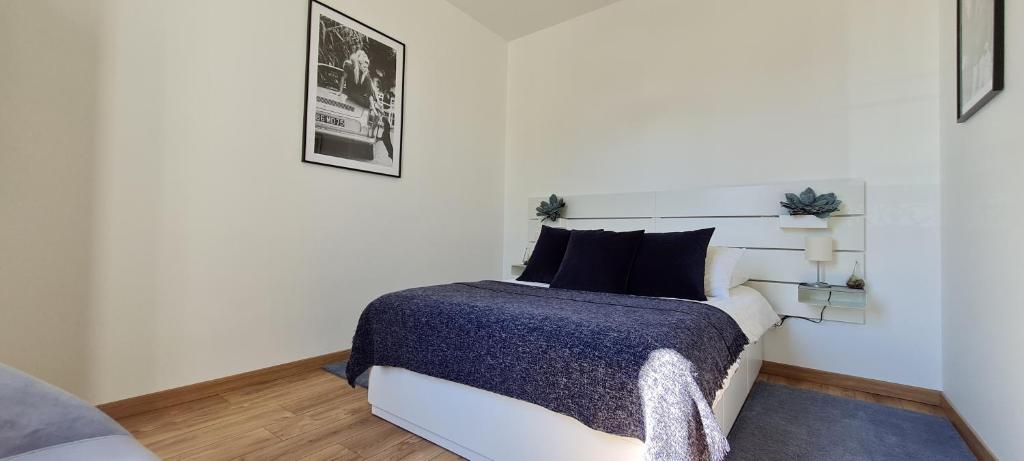 a bedroom with a white bed with a blue blanket at Chez Charles Centre-Parking privé-Hospices-Gare in Beaune