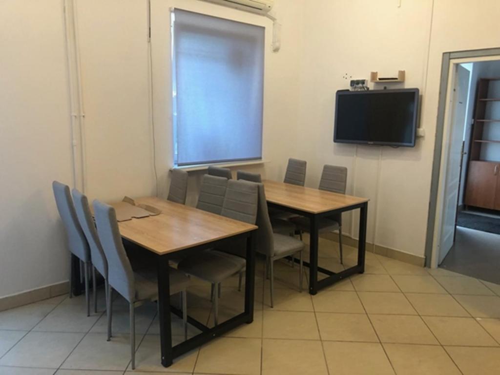 une salle à manger avec une table, des chaises et une télévision dans l'établissement Kwatery Mińsk Mazowiecki, à Mińsk Mazowiecki