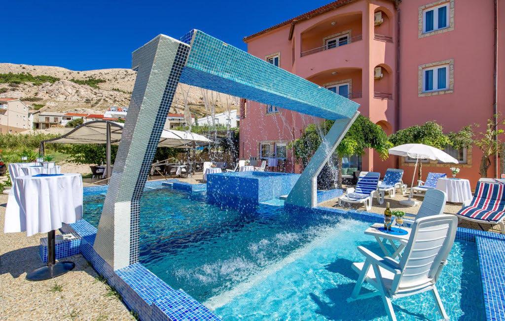 a pool with blue tiles on the side of a building at Bed & Breakfast Valentina in Metajna