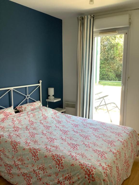 1 Schlafzimmer mit einem Bett mit Blumenbettdecke in der Unterkunft Les Jardins de l’Empereur, Hendaye in Hendaye