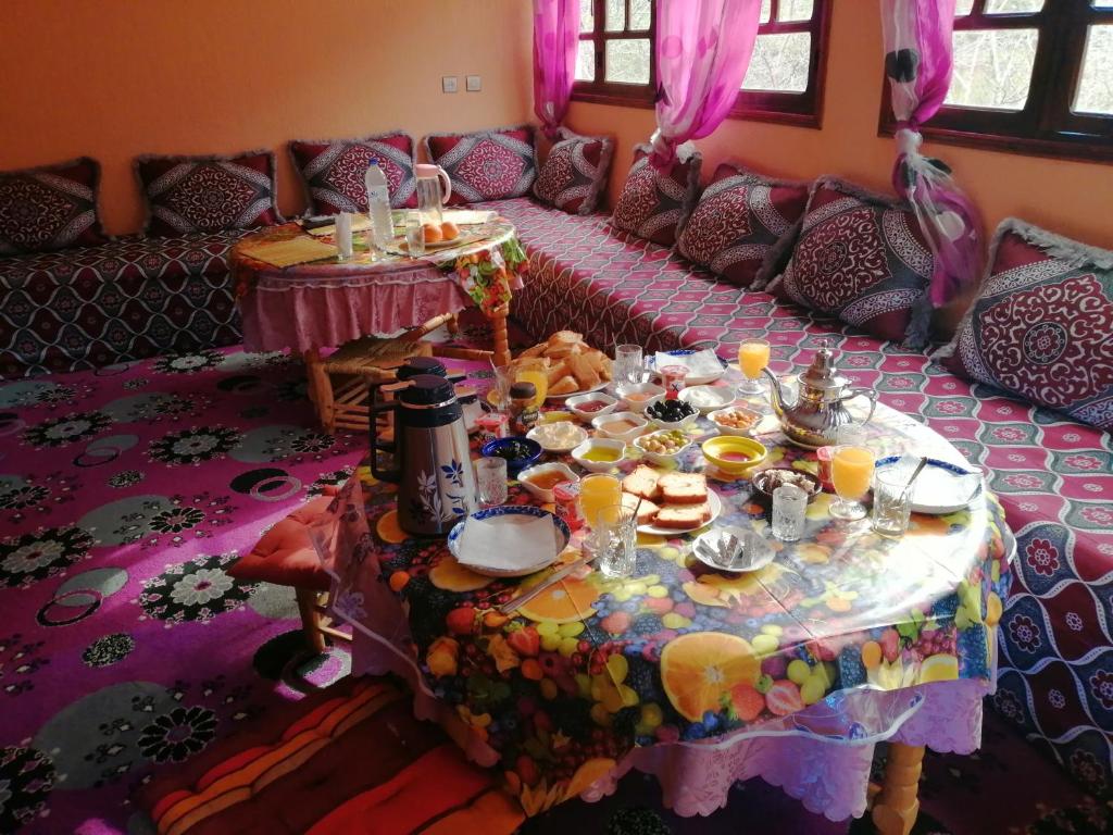 una sala de estar con una mesa con comida. en Dar Atlas, en Imlil