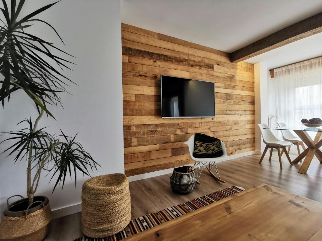 a living room with a wooden accent wall at Oroel in Jaca