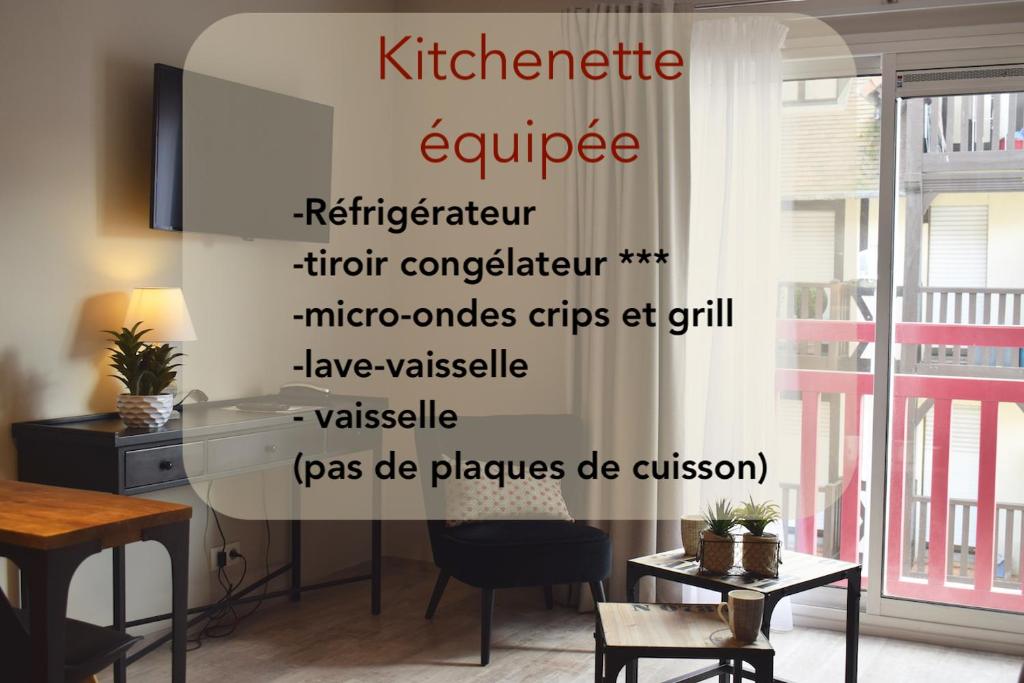 ドーヴィルにあるSuite Appart'Hôtel La Loggia By M Spaのテーブルと簡易キッチン用品を読むサイン付きの部屋