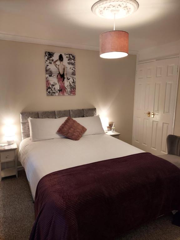 a bedroom with a large bed and a pendant light at LegenDerry B&B in Derry Londonderry