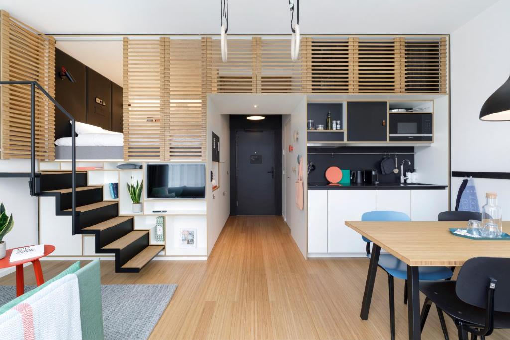 a kitchen and dining room with a staircase and a table at Zoku Copenhagen in Copenhagen