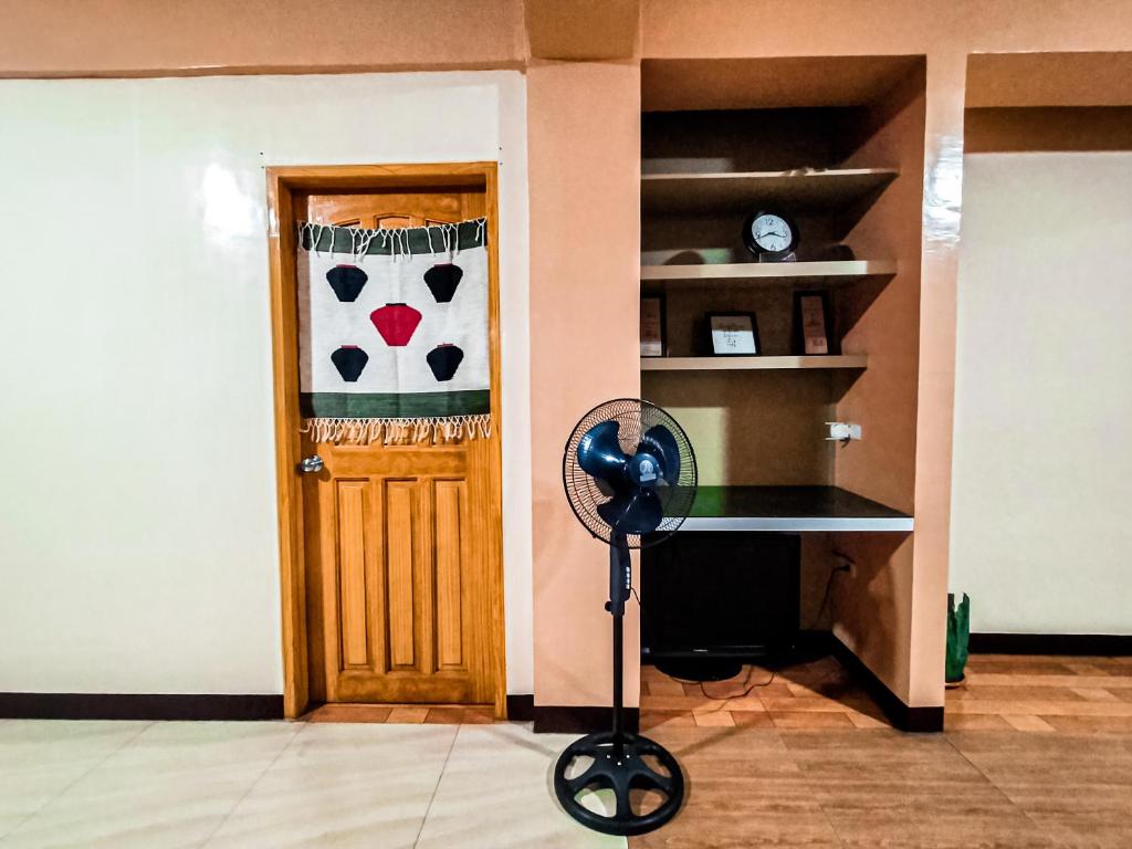 a room with a fan in front of a door at JO-ZA-NA's Hostel(bed and breakfast) in Baguio