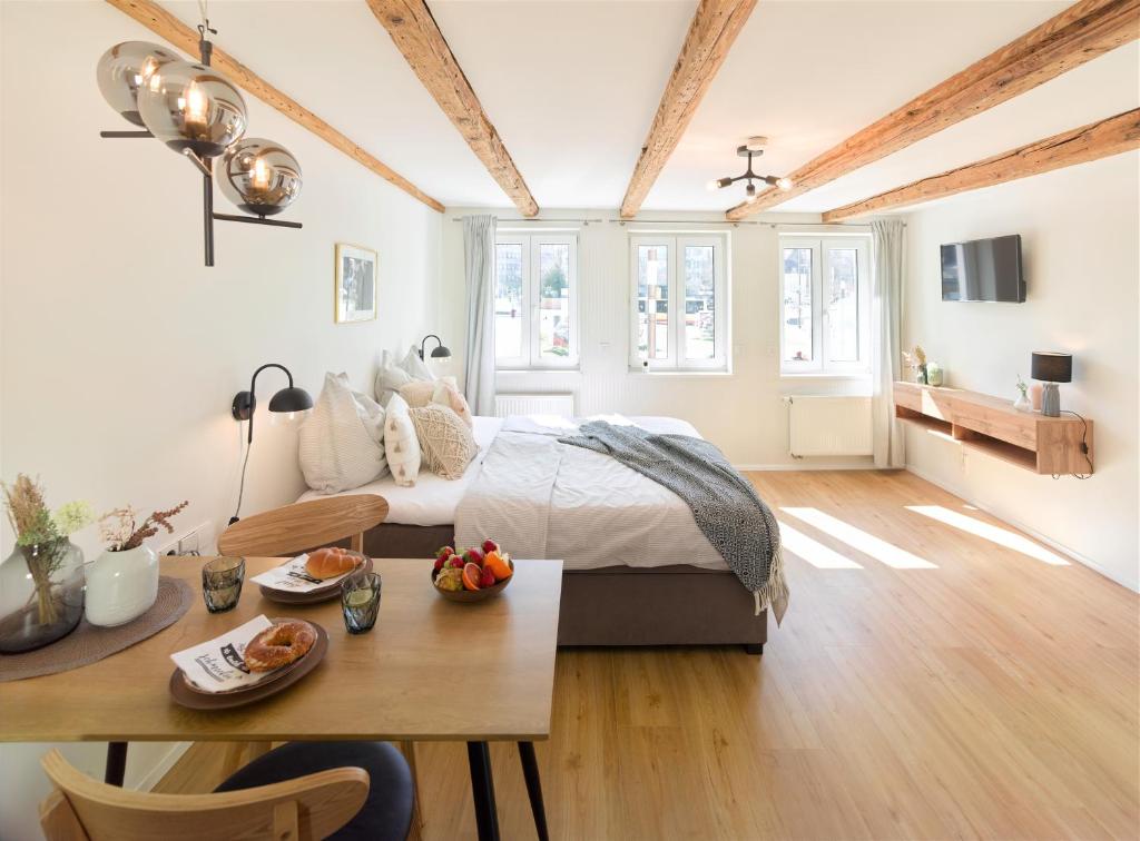 Un dormitorio con una cama y una mesa con comida. en WachtRaum Reutlingen - Altstadt Apartment & Design Rooms an Stadthalle & Marktplatz, en Reutlingen