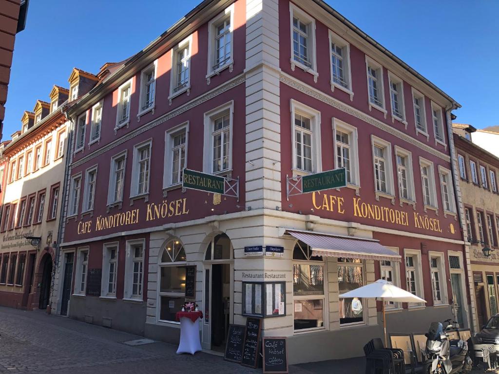 un edificio con dos personas de pie delante de él en Café & Hotel Knösel en Heidelberg