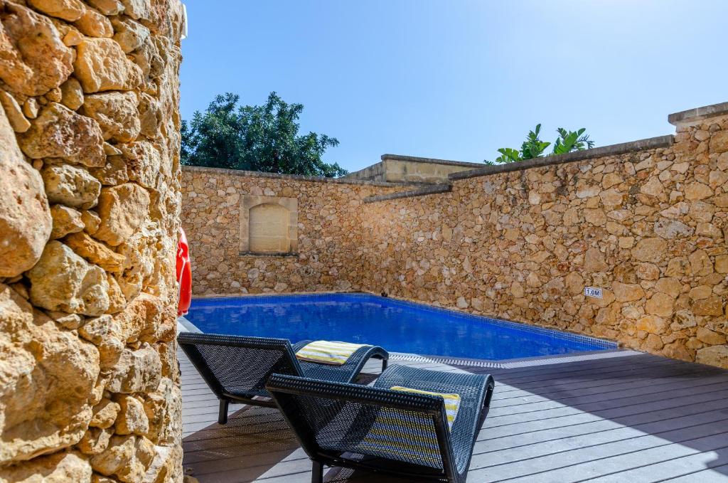 un patio con 2 sillas y una piscina en Gozo Villa w/Private Pool near Beach + AC + BBQ, en Xagħra