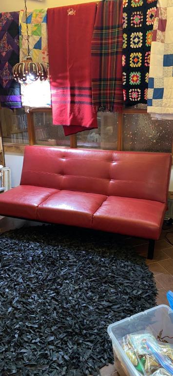 a red leather couch in a room with a rug at The Old Church B&B in Warner