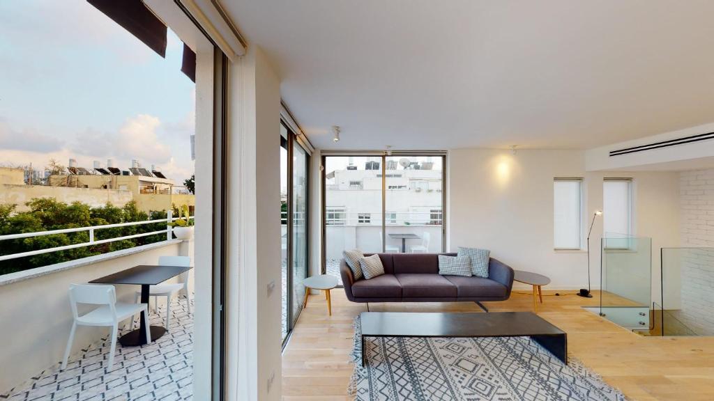 uma sala de estar com um sofá e uma mesa em Authentic 3BR Penthouse in Ben Gurion by HolyGuest em Tel Aviv