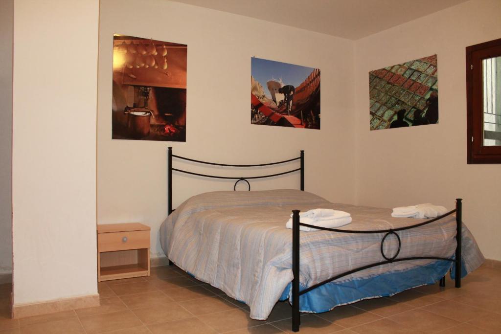 a bedroom with a bed and two pictures on the wall at Porta Del Sole in Manfredonia