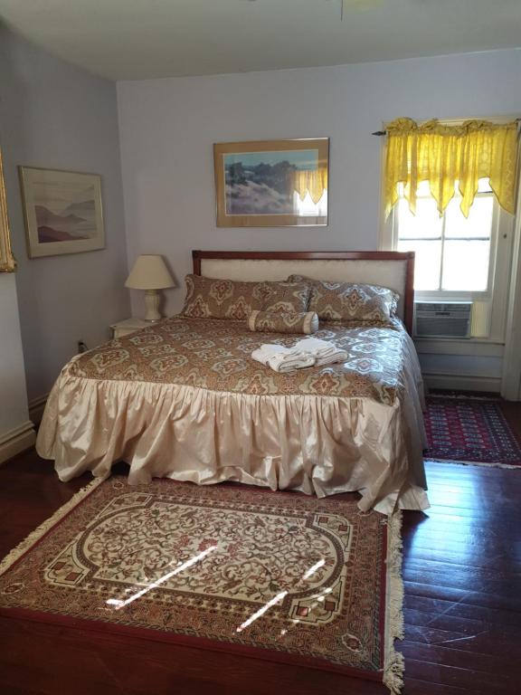 a bedroom with a bed with a rug and a window at Ubon Thai Victorian Inn & Restaurant in Staunton