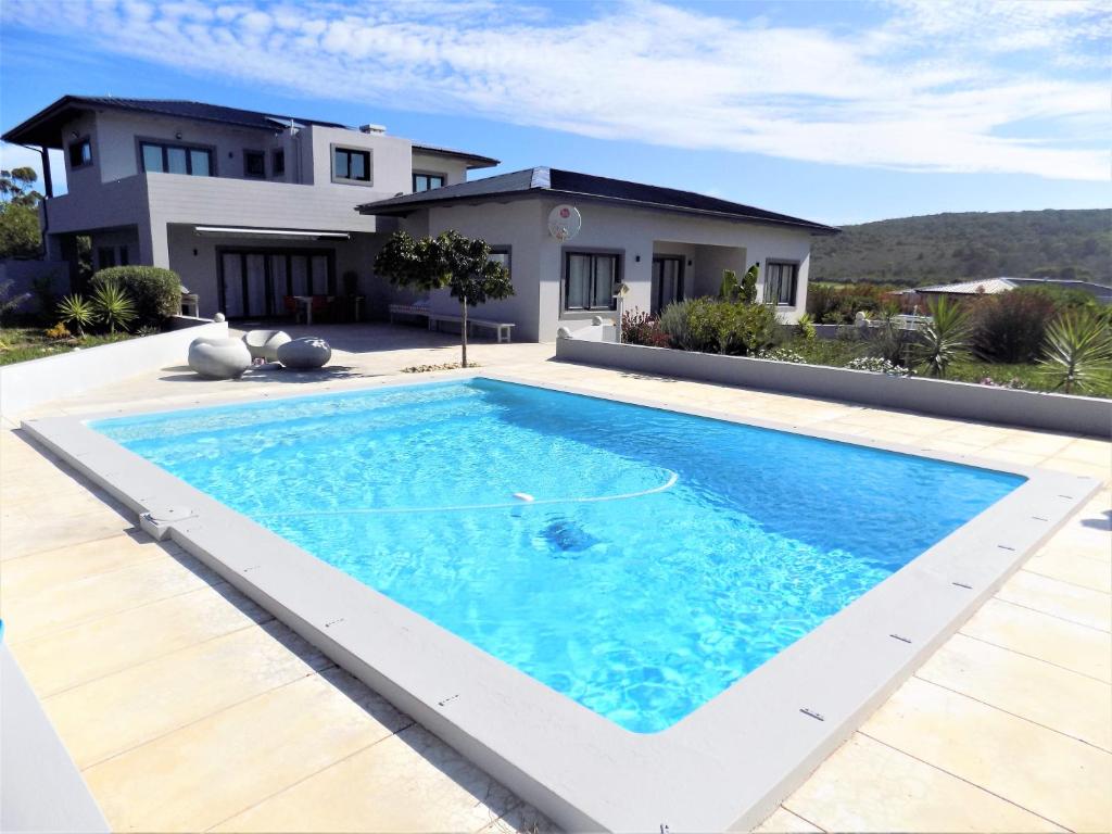 una piscina frente a una casa en Green Goose self catering villa with pool, en Plettenberg Bay