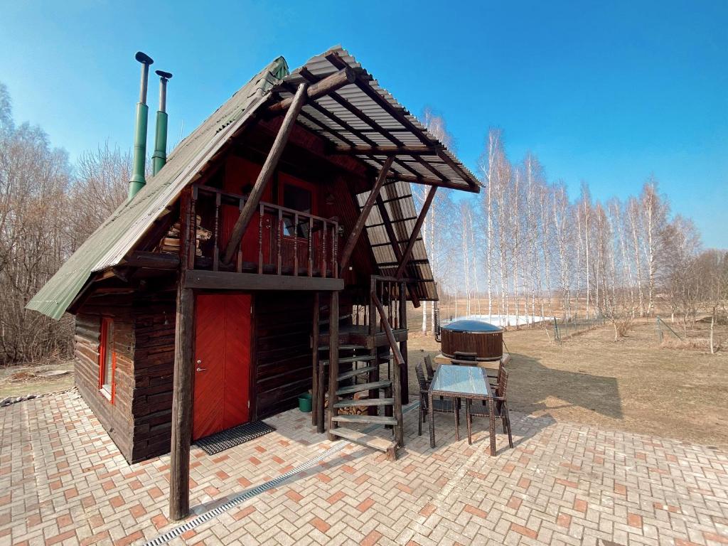 una pequeña casa de madera con una parrilla en un campo en Pirts namiņš Zvaniņi en Vecumnieki