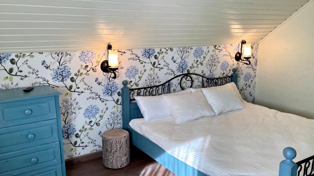 - une chambre dotée d'un lit avec du papier peint bleu et blanc dans l'établissement Drevė, à Skaistgirys