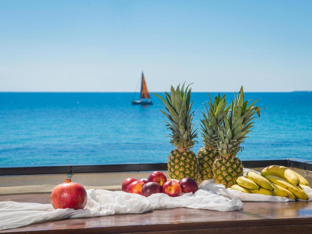 a bunch of fruits on a table by the ocean at Anastasia Miramar Deluxe Apartments in Zakynthos