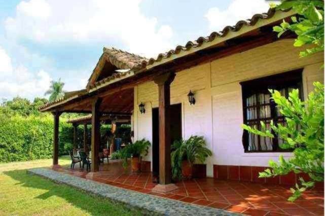 une maison avec une terrasse dans la cour dans l'établissement Villa de las Palmas de Rozo Palmira, à Rozo