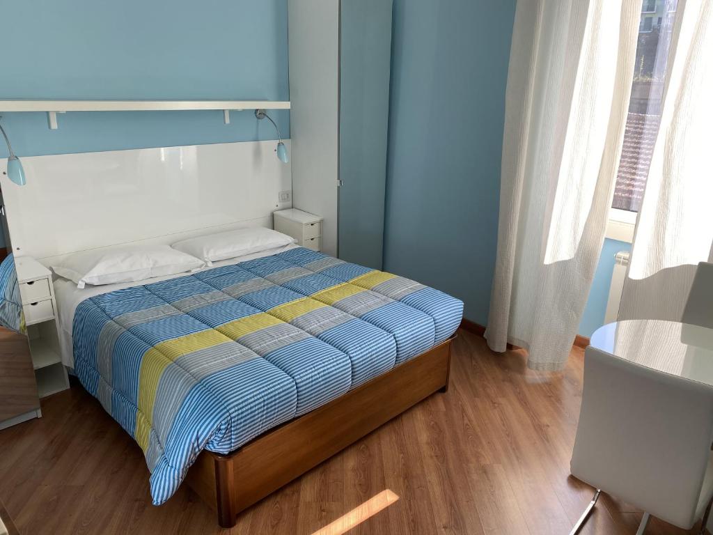 1 dormitorio con 1 cama con pared azul en Luna Rossa Roma Guest House, en Roma