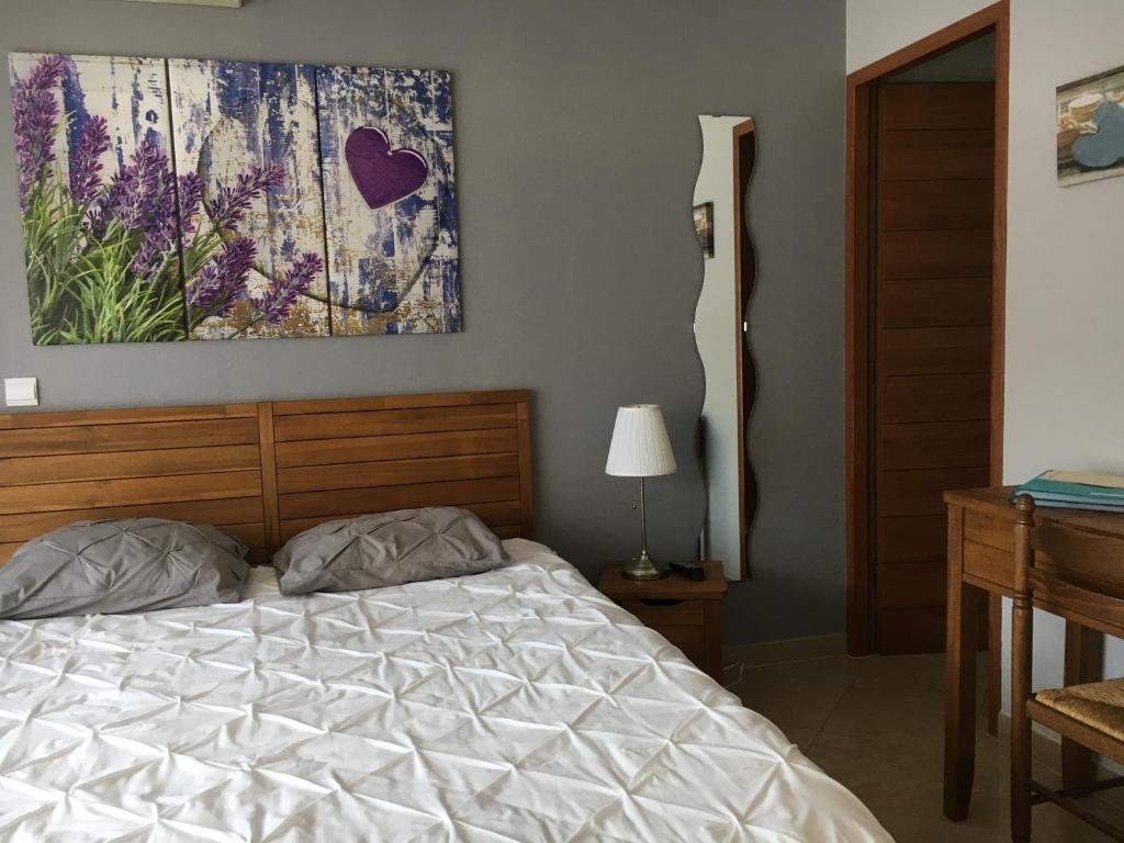1 dormitorio con 1 cama y una pintura en la pared en Les Lavandes, en Alleins