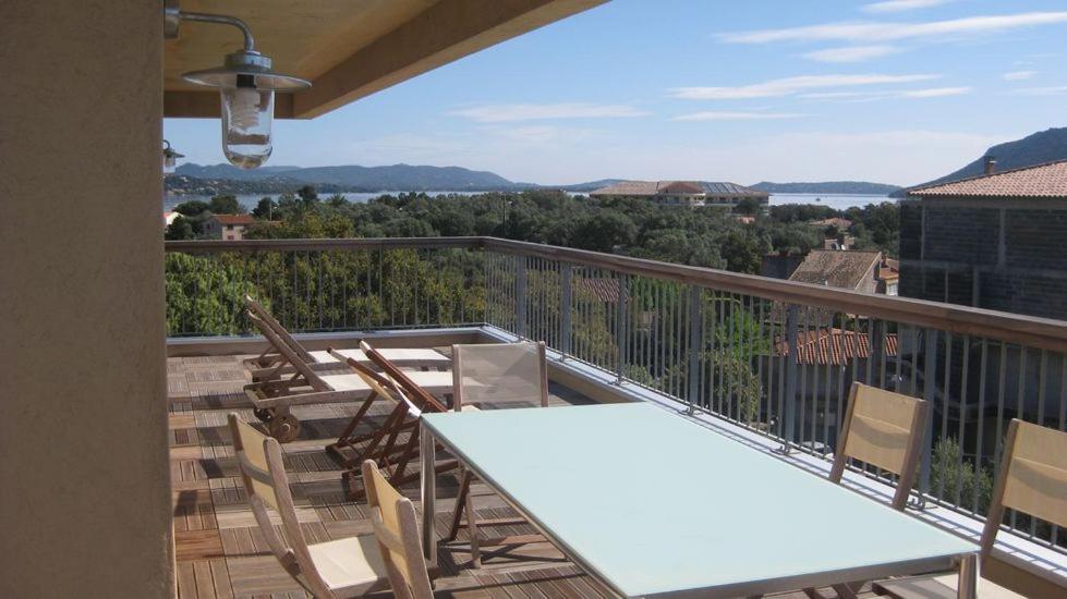 un balcon avec une table et des chaises et une vue dans l'établissement Appartement Terrasse dernier étage LES TERRASSES DE VIGNOLA, à Porto-Vecchio