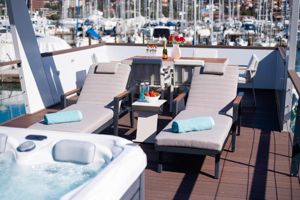 balcone con sedie a sdraio e vasca idromassaggio di Adria Portorož Luxury Houseboat a Portoroz
