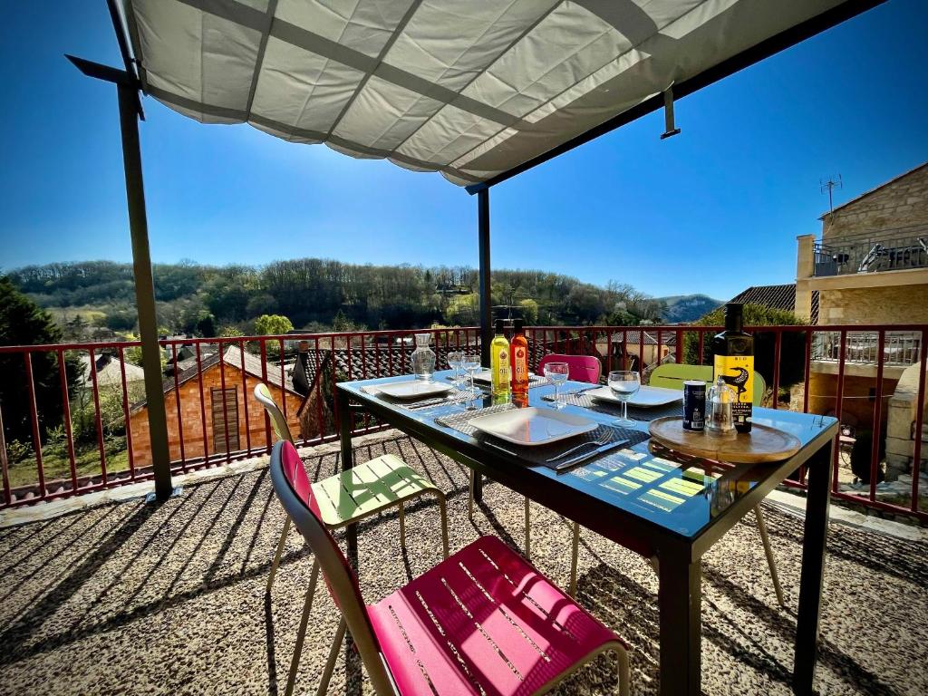 un tavolo e sedie su un balcone con vista di Cottage du Capiol en Périgord a Cénac-et-Saint-Julien