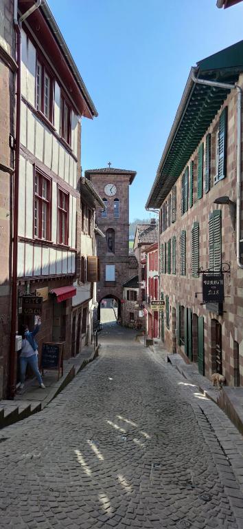 a city street with buildings and people walking down it at Gîte ULTREIA Vertes Montagnes in Saint-Jean-Pied-de-Port