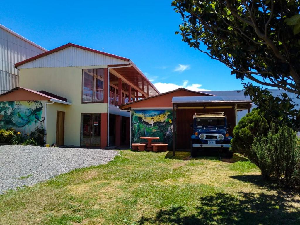 una casa con un camión aparcado delante de ella en Hotel La Puesta Del Sol B&B, en Monteverde