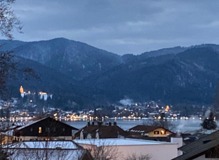 泰根塞的住宿－Zentral am See in Tegernsee，一座有雪覆盖的建筑和山地的城市