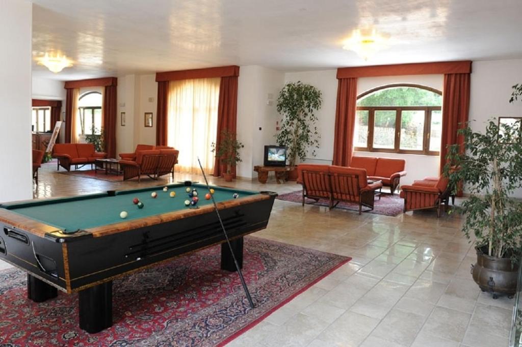 salon ze stołem bilardowym i krzesłami w obiekcie Hotel Villa Rosa w mieście Martina Franca