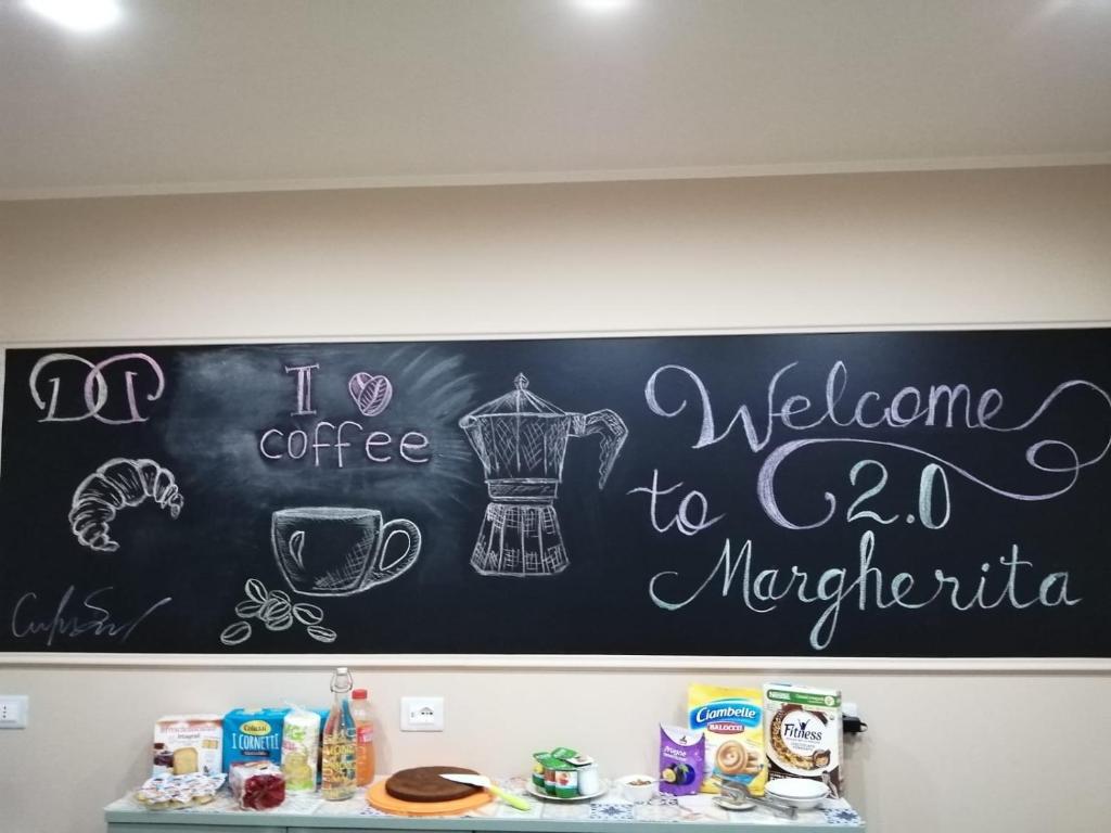 a chalkboard with a welcoming sign on a wall at Margherita 2.0 in Cosenza