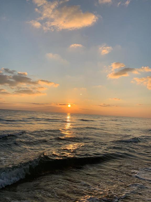 una puesta de sol en la playa con el océano en Ralla Nilaveli en Nilaveli