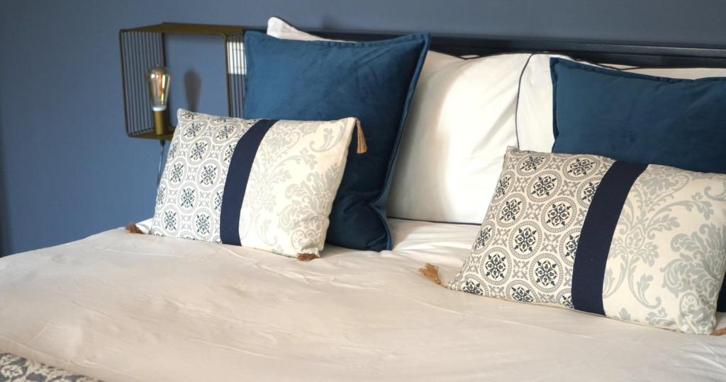 a bed with blue and white pillows on it at LaMalatestina Suite - Apartment in front of the Castle in Rimini