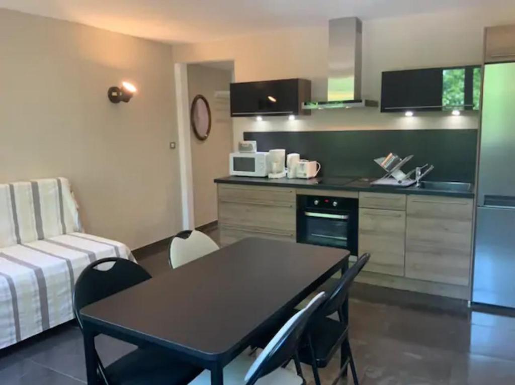 une cuisine avec une table et des chaises dans une pièce dans l'établissement Centre Historique de Fréjus - face à la mairie, à Fréjus